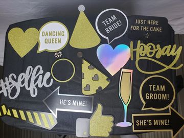 Silver, black, gold signs, arrow, heart, champagne glass, flat hand held hats, ring & tie. Hooray