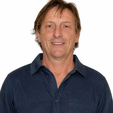 Middle-aged man in a casual dark blue shirt, smiling at the camera.