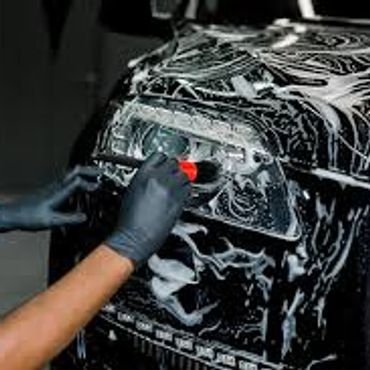 Person polishing a car headlight with gloves on.