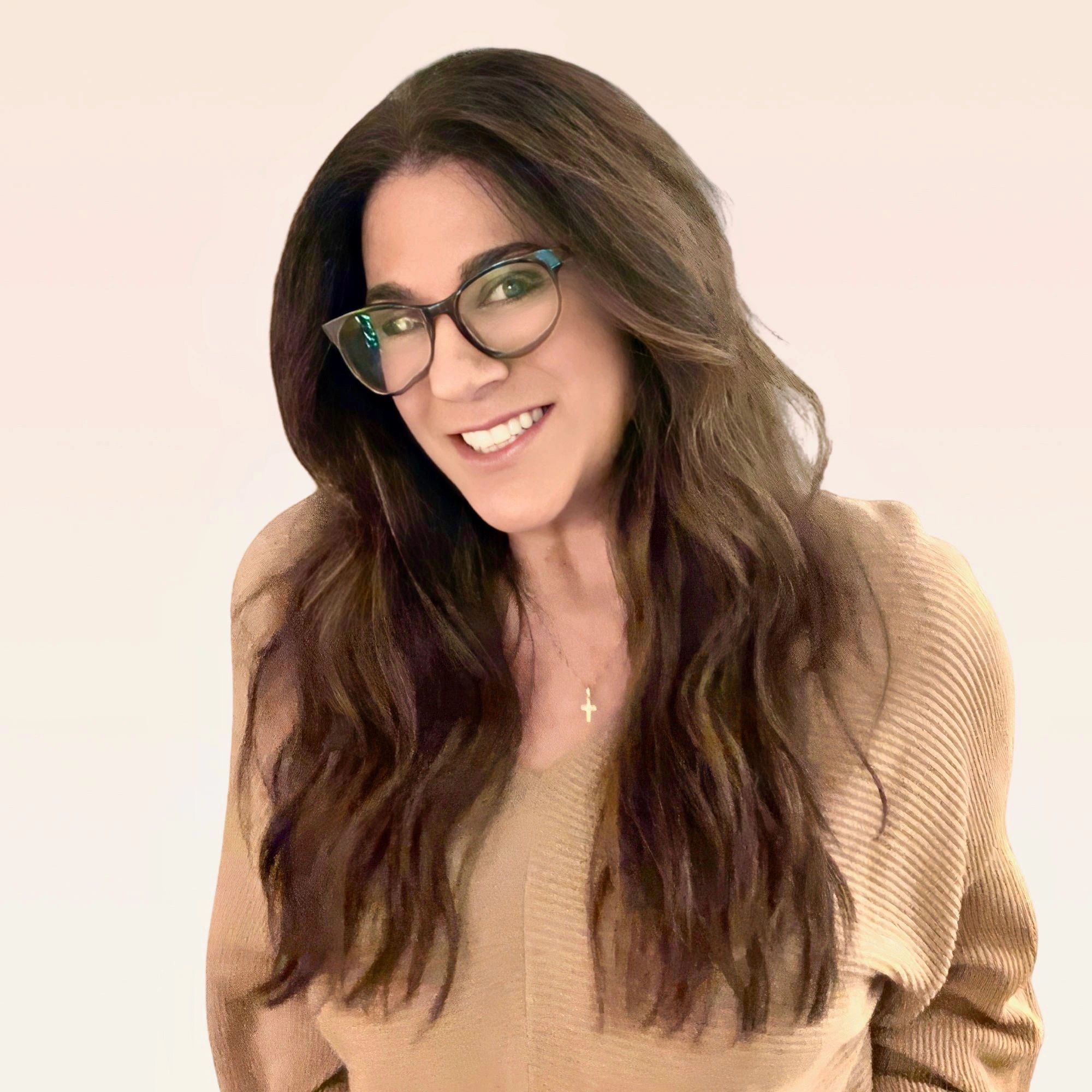 Smiling woman with long hair and glasses wearing a beige sweater.