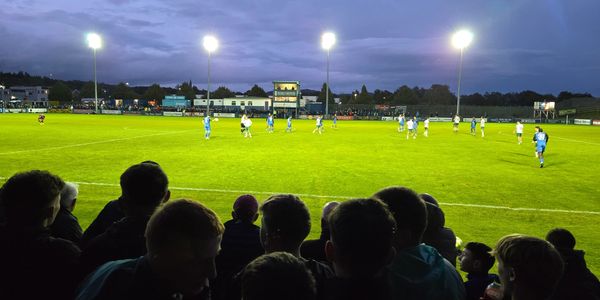 Evening soccer match under bright stadium lights.