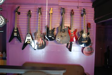 A wall with many guitars hanging on it