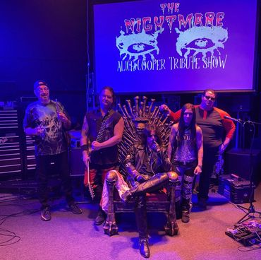 A Band called The Nightmare Alice Cooper Tribute Show posing for a group photo in front of a screen