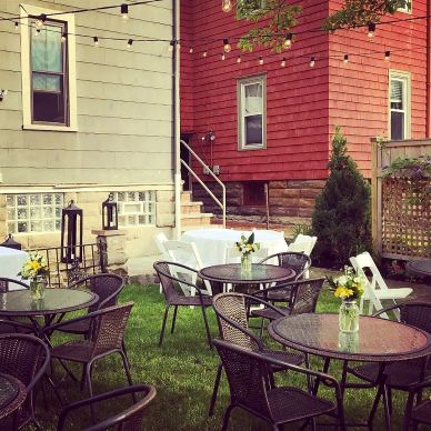 Outdoor patio seating with tables, chairs, and string lights.