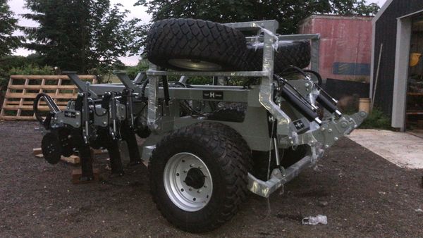 Photograph of a large subsoiler for a seed drill in its folded up position.
