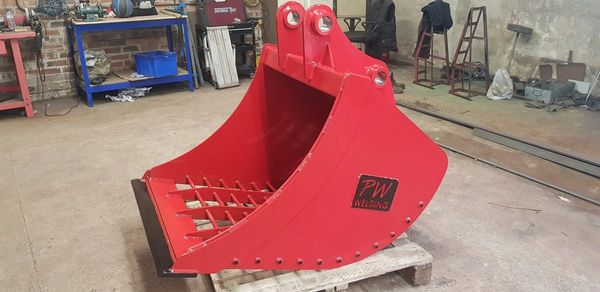 Photograph of a red grading bucket on a pallet.