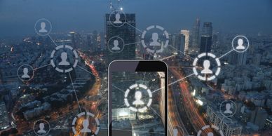 Image of cell phone with city in the background, with images of avatars connected