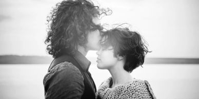 Couple sharing a tender moment by the water.