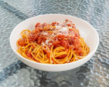 Spaghetti with tomato sauce and grated cheese.