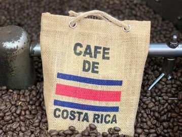 A burlap sack labeled 'Cafe de Costa Rica' surrounded by coffee beans.