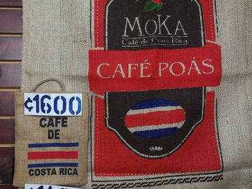 Burlap coffee bags labeled Café Poás and Café de Costa Rica with price tags.