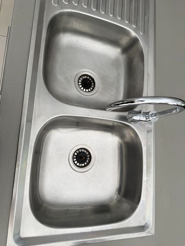 Double stainless steel kitchen sink with a modern faucet.