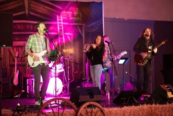 Two men and a woman are performing at a music event