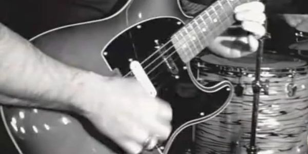 Close-up of a person playing electric guitar.