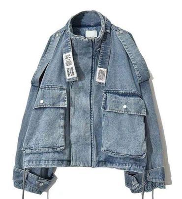 Denim jacket with large front pockets and unique strap details.