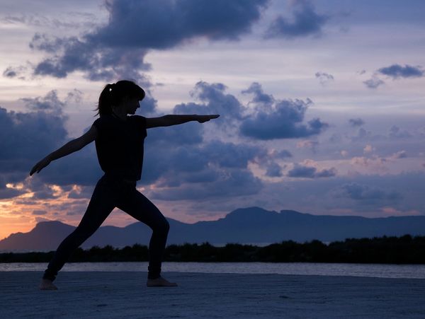 Silhouette of a person doing yoga at sunset.