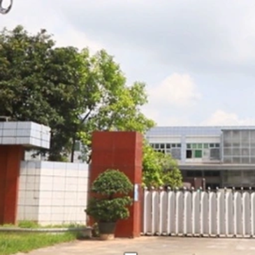Entrance gate to a modern building with greenery.