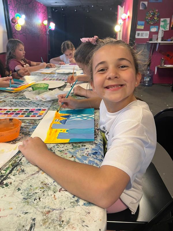 oung artists expressing creativity with paint and paper in class