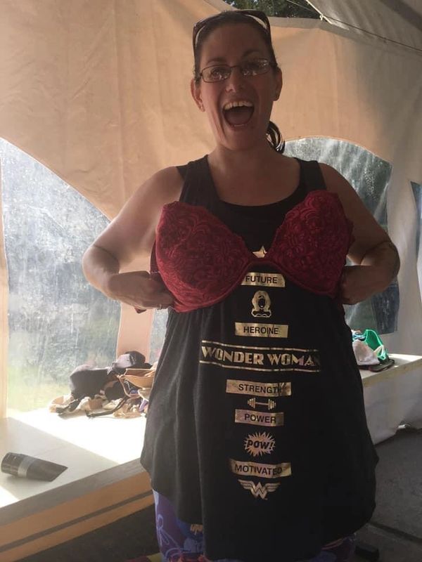 Goddess Jenn holding up a red bra t be hooked into the chain