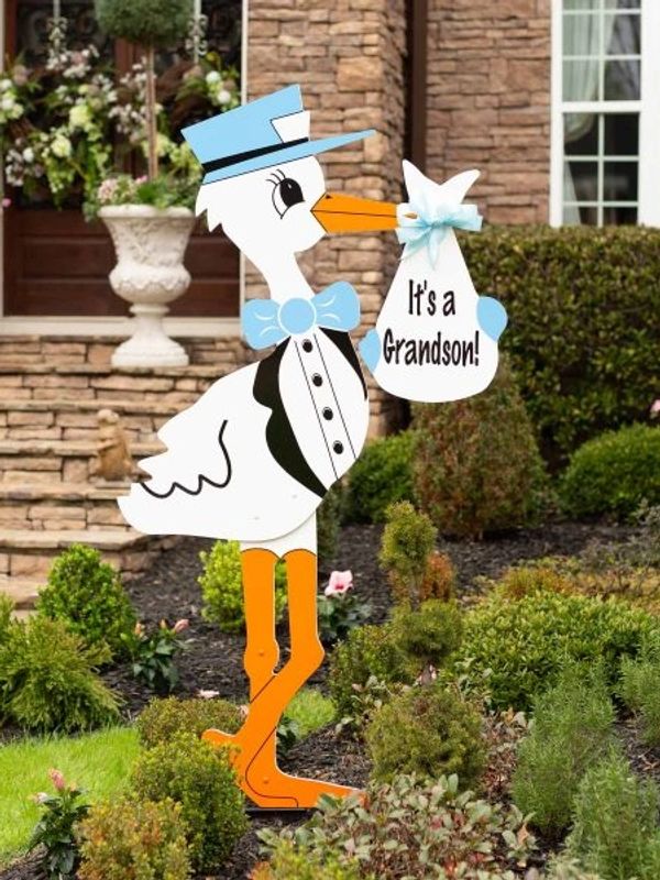 Stork yard sign  holding a sign that says Its a Grandson!