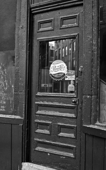 Christopher LeClaire Photography. Boston North End black and white photo. Antique city door. Pepsi.