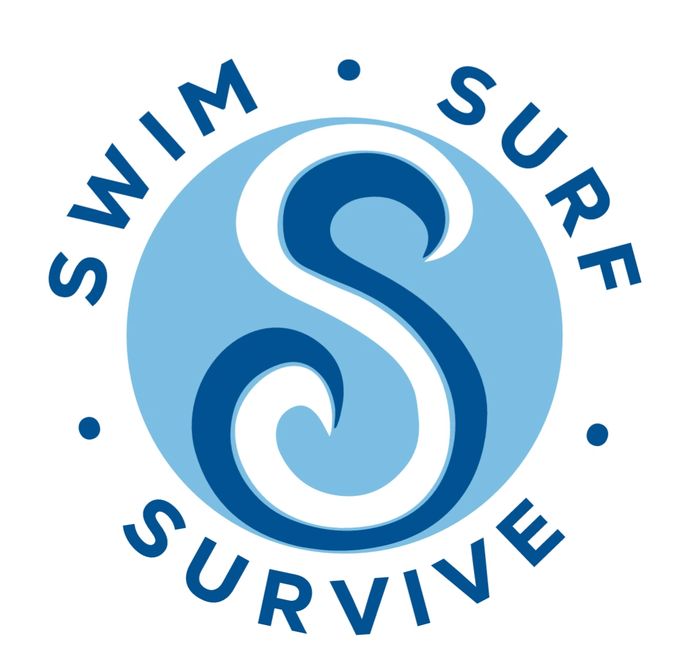 Three men holding surfboards, looking at the ocean during sunset.