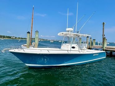 Teal centre console boat at Cape Cod marina dock after professional detailing service