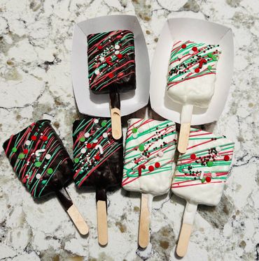 Festive chocolate popsicles decorated with red, green, and white sprinkles and drizzle.