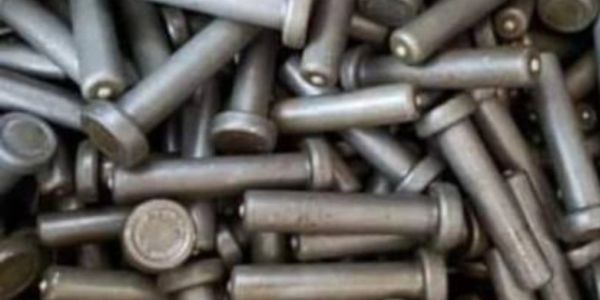 A pile of metallic bolts with hexagonal heads.