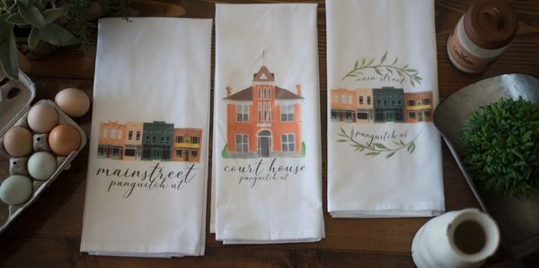 Decorative kitchen towels with small town illustrations.