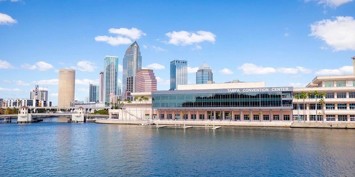Tampa Convention Center by the waterfront with city skyline in the background.