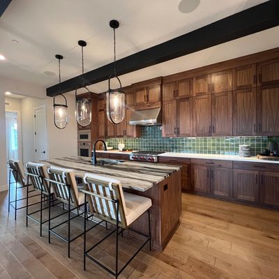 Clean kitchen with wooden cabinets, green backsplash tiles, and a stove hood after Troutdale maids