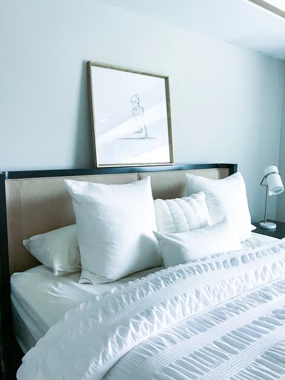 Neatly made bed with white pillows, representing our Maids in Happy Valley and Clackamas OR.