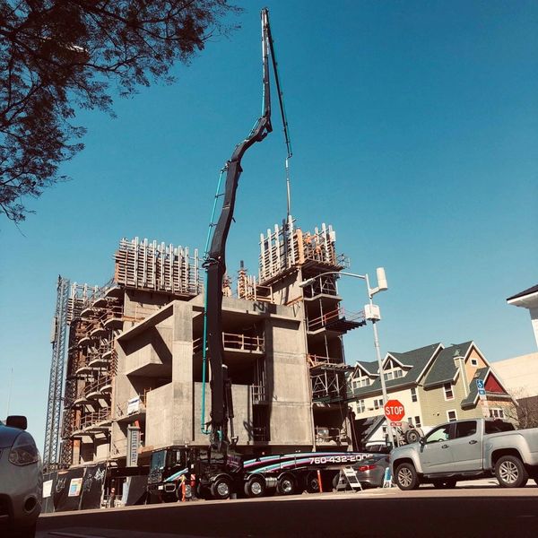 Concrete pump truck at building construction site.
