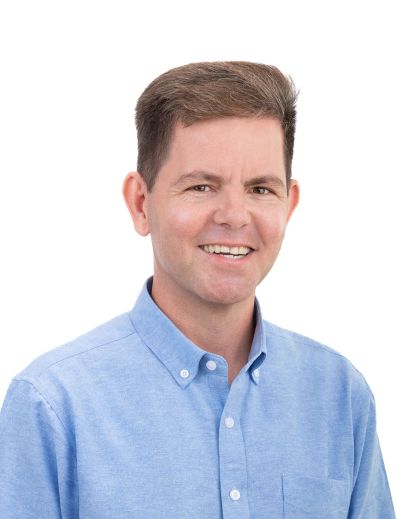 Smiling man in blue shirt.