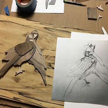 A pencil drawing of birds with the similar wood cut out.