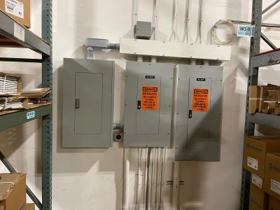 Completed commercial electrical panel installation with labeled equipment and conduit