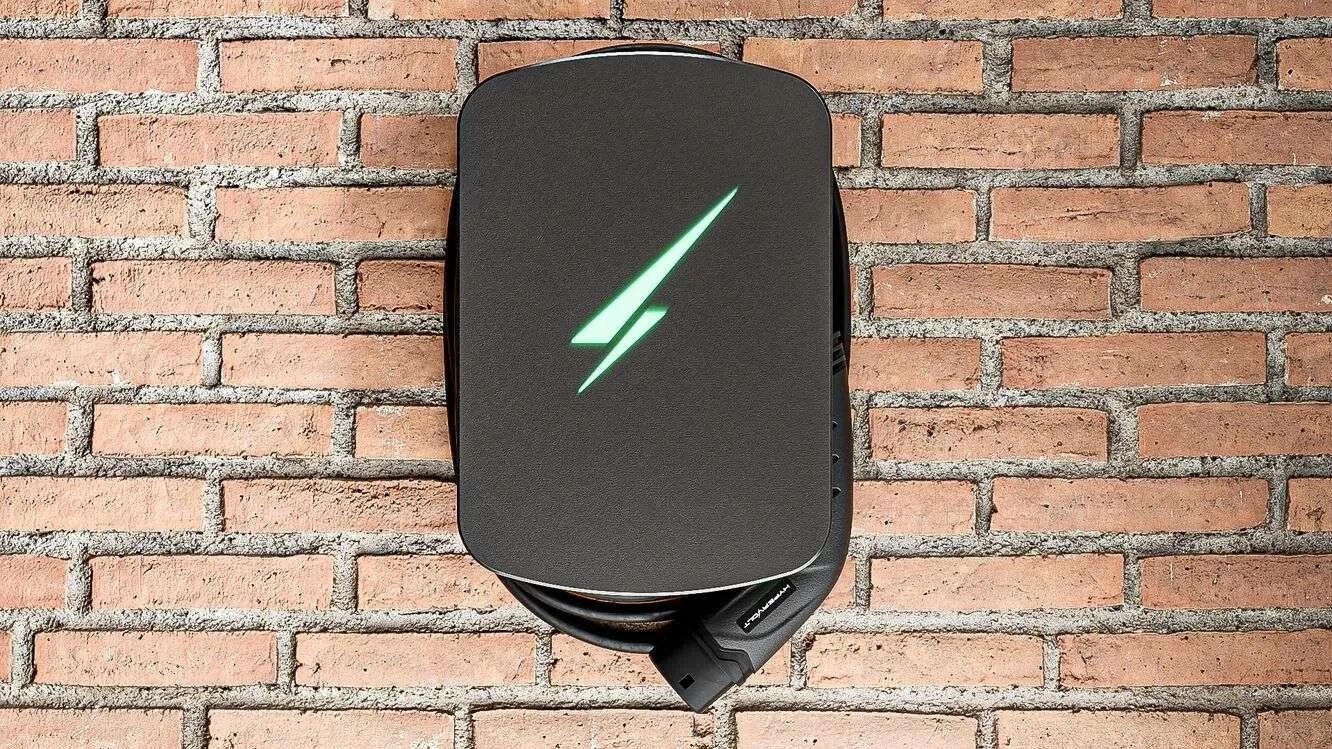Electric car charging station on brick wall.