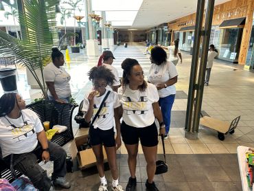 Group of people wearing white shirts inside a mall area.
