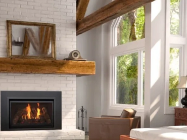 Cozy bedroom with fireplace, leather chairs, and large windows.