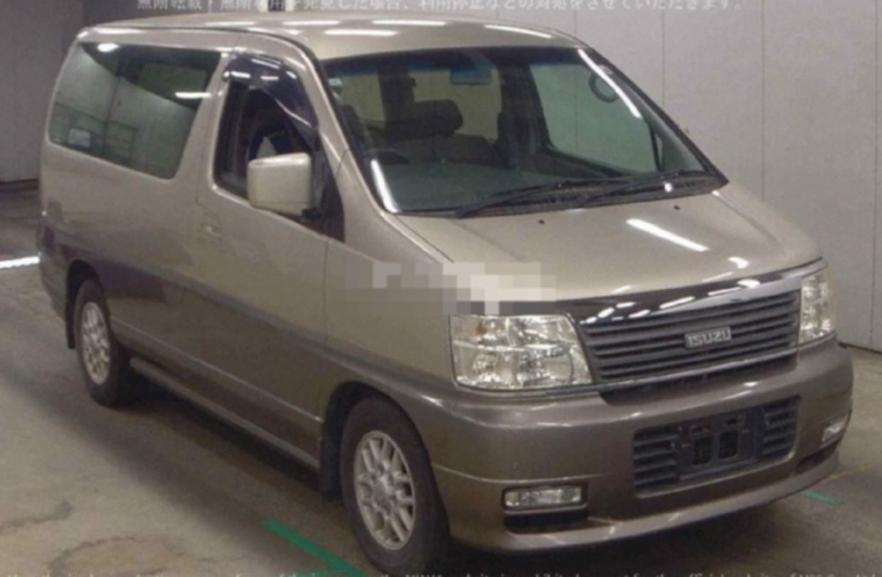 Beige Isuzu minivan parked indoors.
