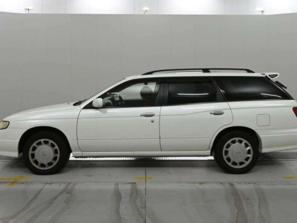 White station wagon car parked indoors with black tinted windows.