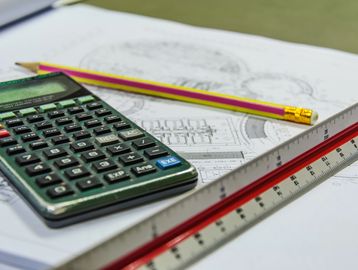 A calculator along with a pencil kept on a copy