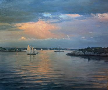 Sailboats on calm water at sunset.