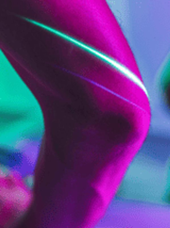 Person using a device with neon lighting highlighting their shoulder and knee.