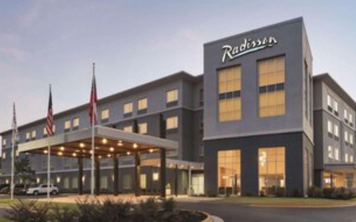 Exterior view of a modern Radisson hotel building at dusk.