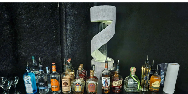 A bar counter with various liquor bottles and cocktail glasses.