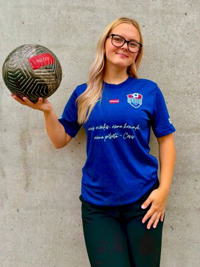 Young woman holding a soccer ball, smiling.