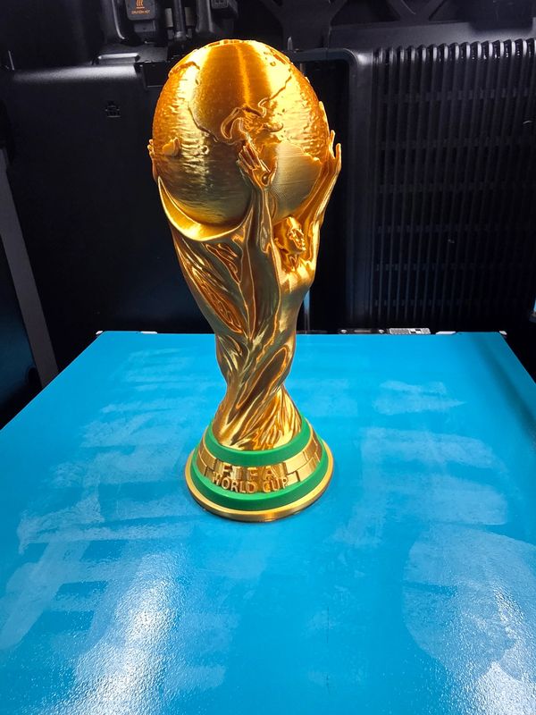 Golden FIFA World Cup trophy on a blue surface.
