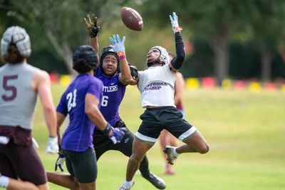 Players jumping to catch a football during a game.